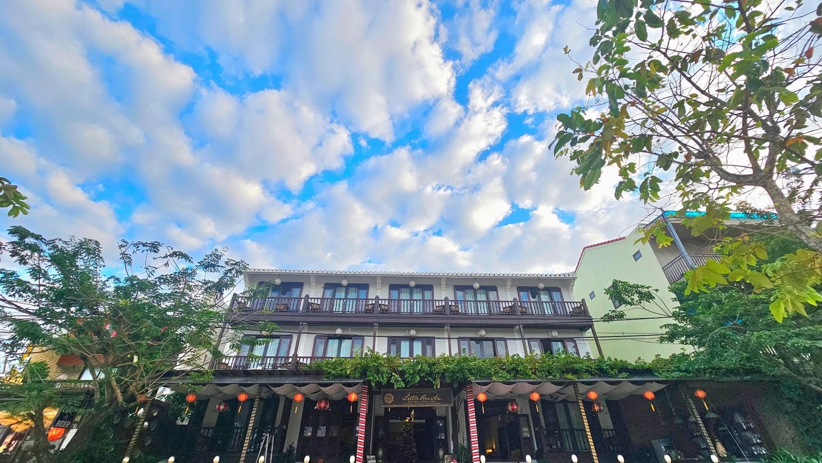 Low-angle view of the Little Hoi An heritage facade beneath a blue sky