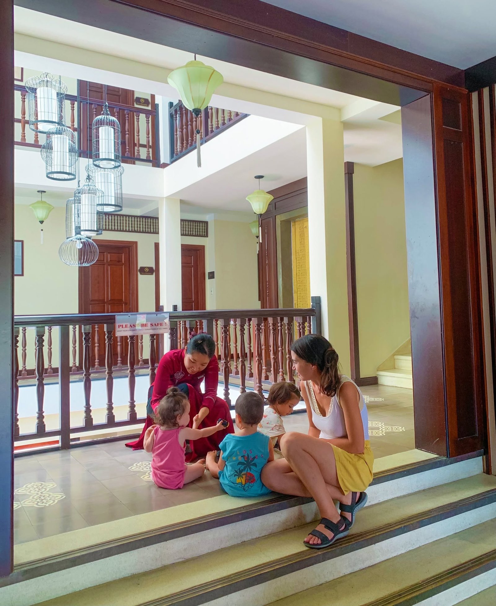 Little Hoi An team member sharing a warm moment with a family and children