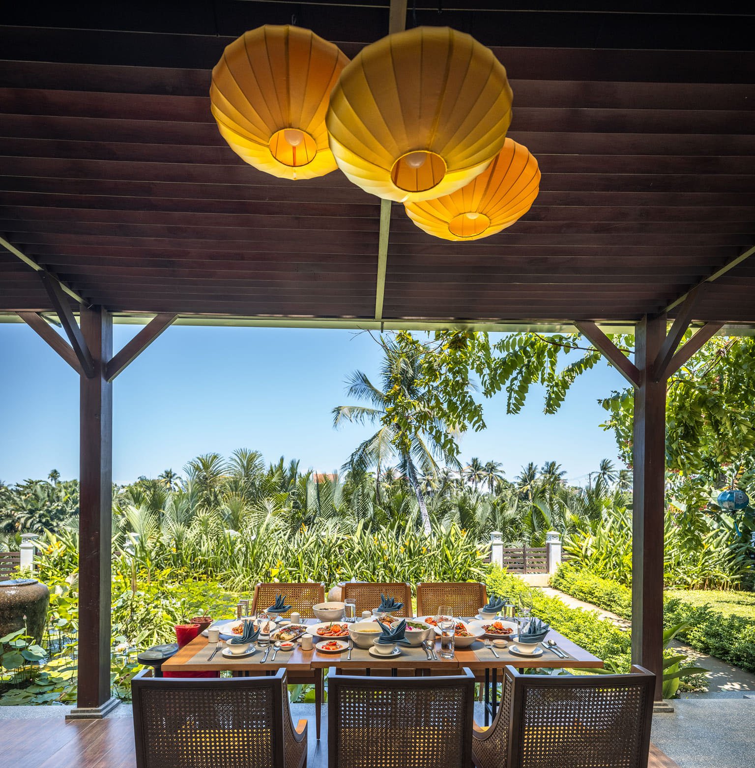 Lantern-lit garden dining overlooking the green landscape