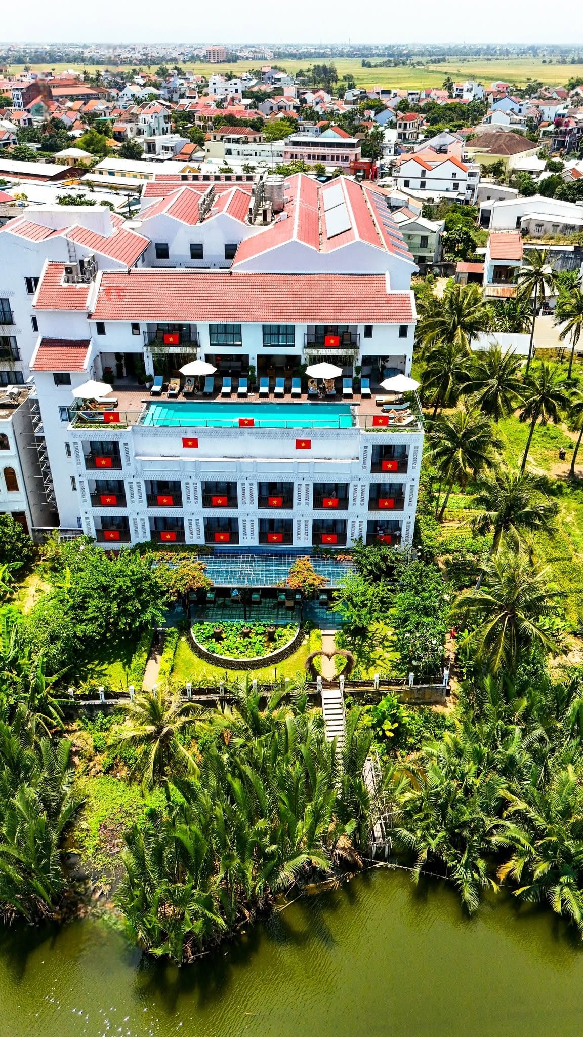 Aerial view of Little Oasis Hoi An, its rooftop pool and river landscape