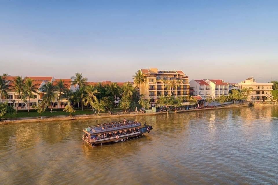 Little Riverside Hoi An with a river cruise passing at sunset